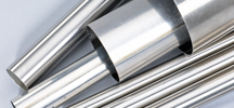 Several stainless steel tubes piled together on a white background