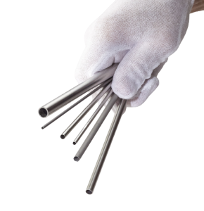 Gloved hand gripping a bundle of hollow stainless steel tubes of varying diameters.